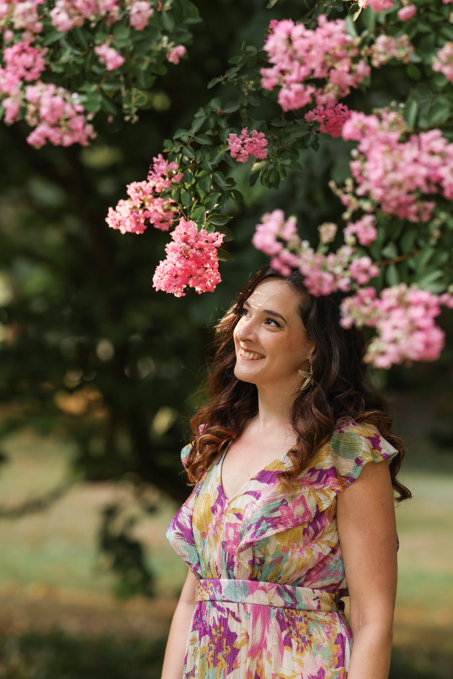 Charlotte Maturano regardant des fleurs roses en jardin