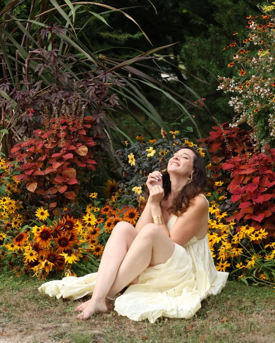 Charlotte Maturano, accompagnement perte de poids près de Tarbes, assise souriante devant un massif fleuri