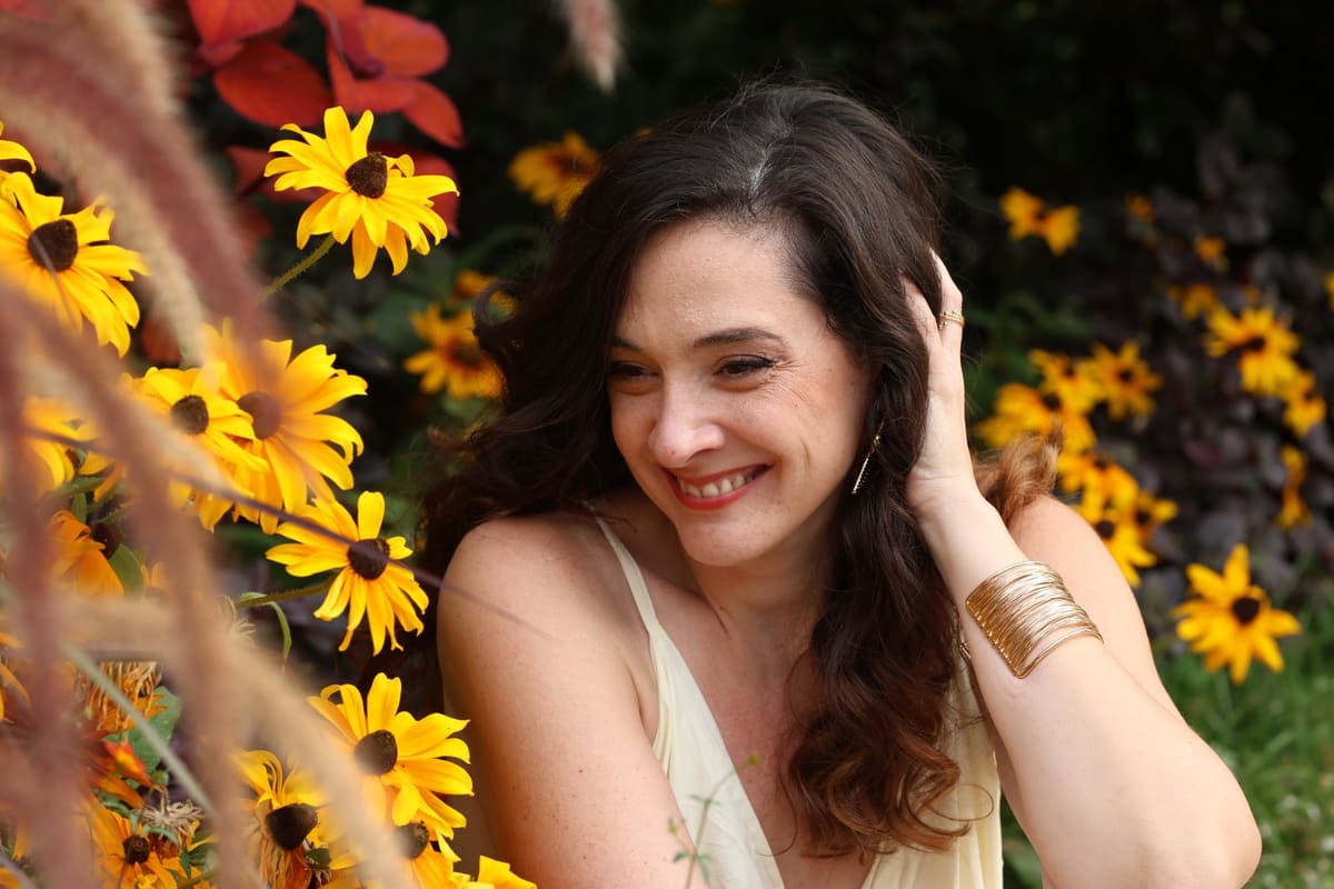 Charlotte Maturano, praticienne en micronutrition près de Tarbes, souriante au milieu de fleurs jaunes